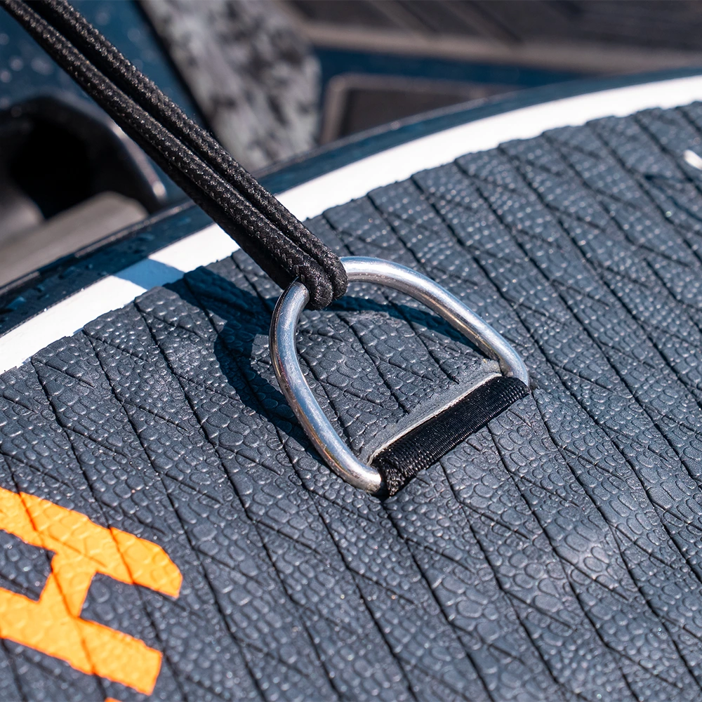 Close-up of a metal ring on a textured surface with a brand logo.
