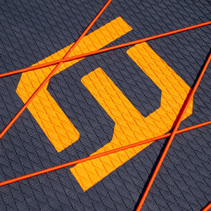 Close-up of a textured surface with an orange logo and orange lines.