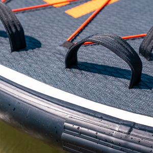 Close-up of a sled with a black handle and orange accents on a black surface.