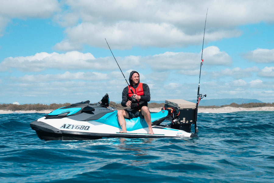 Person on a jet ski fishing in the ocean with a clear sky.