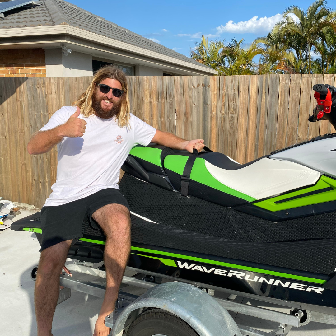 man smiling sitting on jet ski