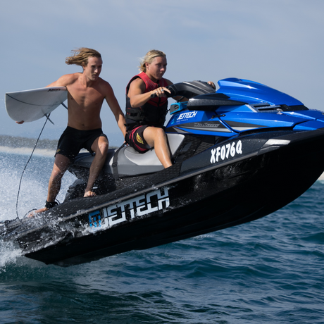 jet ski jumping with man holding surf board