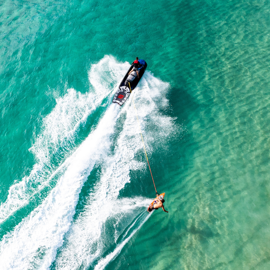 man surfing behind jet ski